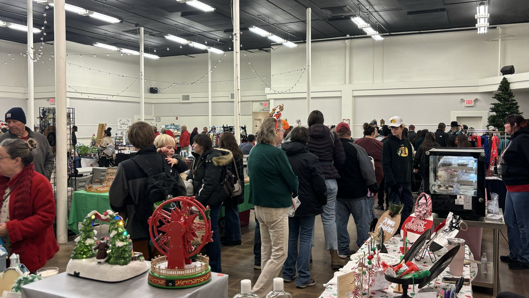 Shoppers browsing vendor booths in the hall at the Mingle Jingle Christmas Bazaar